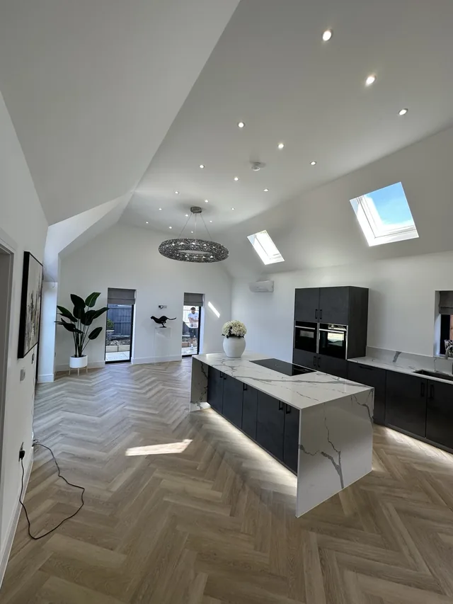Recessed downlights, a circular pendant and lighting beneath the kitchen island.